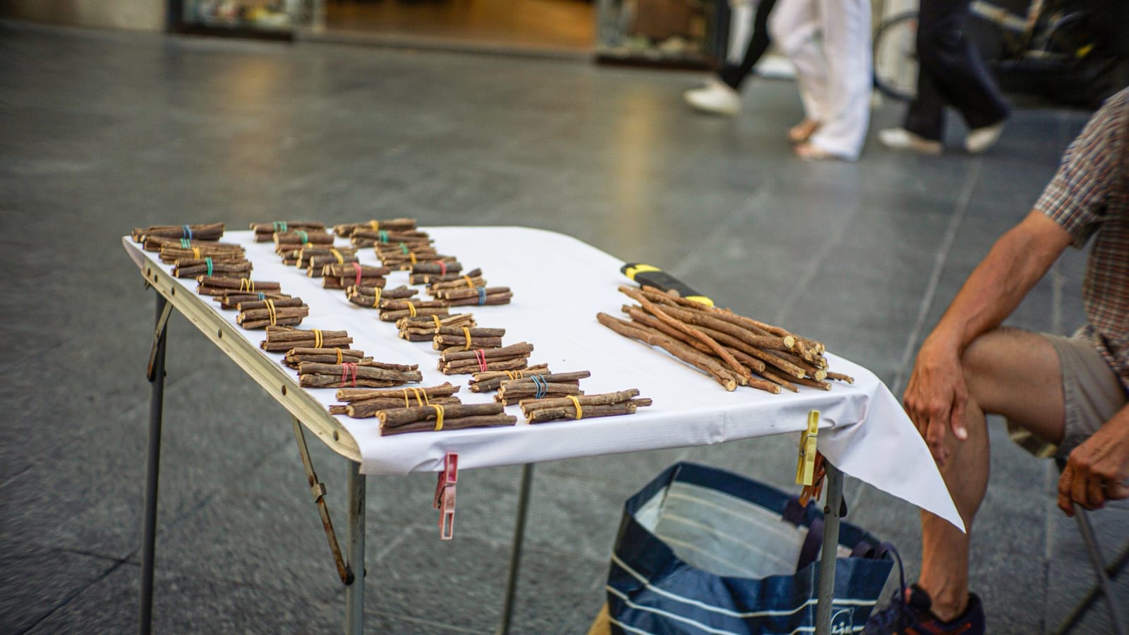 Bundles of licorice roots arranged on a white market table